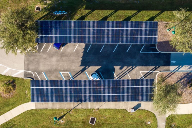 Carport fotowoltaiczny nad parkingiem firmy z ładowarkami dla samochodów elektrycznych.